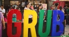Colourful GRUB letters at The Grub Fest, surrounded by festival attendees in New Delhi.